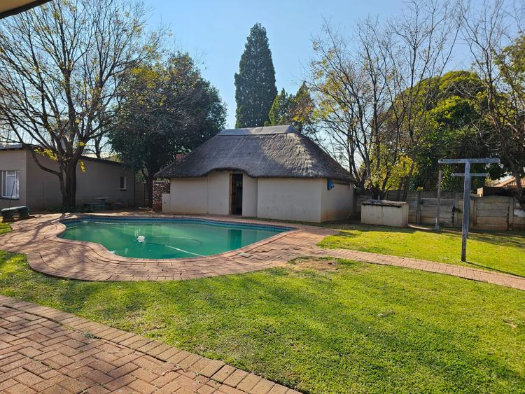 The thatched boma beside the pool, under the trees