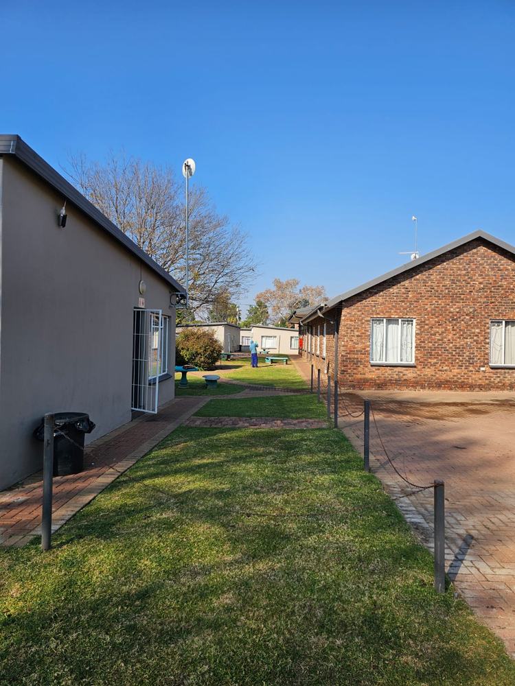 A strip of lawn and a paved path between two rows of units