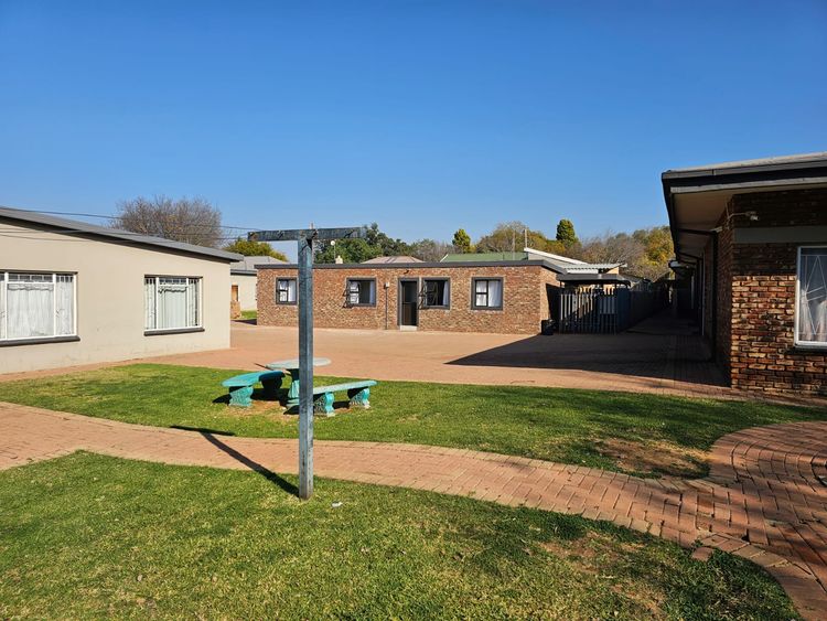 A rotary washing line and picnic benches on the lawn between the units