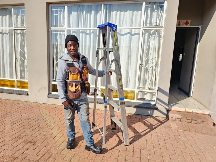 Nguni's maintenance man with a ladder outside one of the units